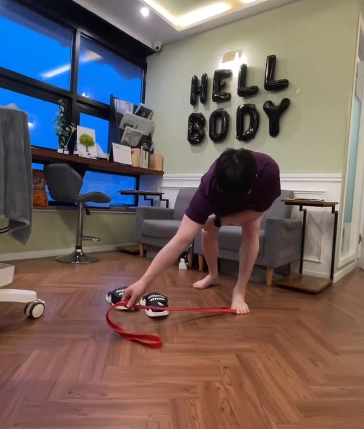HELL BODY 풍선 글자가 붙은 센터 안에서 보라색 유니폼을 입은 사람이 고무 밴드를 집고 있다